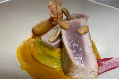 Plat gastronomique composé de viande, légumes, champignons, sauce caramélisée et croustillant sur une assiette décorative.