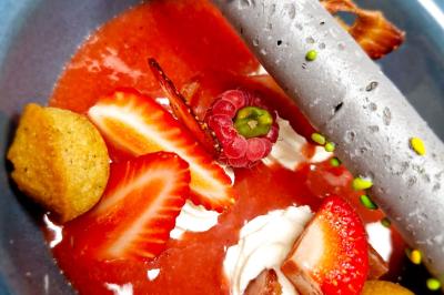 Plat gastronomique composé de viande, légumes, champignons, sauce caramélisée et croustillant sur une assiette décorative.