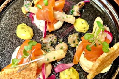 Plat gastronomique composé de viande, légumes, champignons, sauce caramélisée et croustillant sur une assiette décorative.