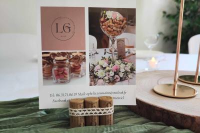 Salle de réception avec tables rondes dressées, nappes blanches, chemins de table en dentelle et décoration élégante.
