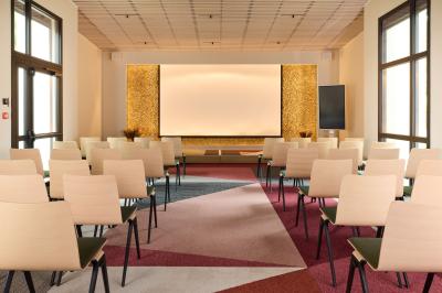 Salle à manger lumineuse avec une grande table en bois, des chaises en rotin et des étagères décoratives en arrière-plan.