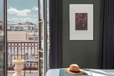 Chambre d'hôtel moderne avec lit double, décoration élégante, photos encadrées et vue sur une salle de bain attenante.