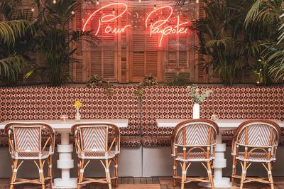 Chambre d'hôtel moderne avec lit double, décoration élégante, photos encadrées et vue sur une salle de bain attenante.