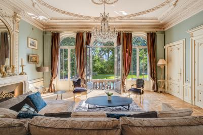 Salle de bain moderne avec carrelage marron, baignoire, fenêtre lumineuse, sèche-serviettes blanc et meuble en bois.