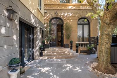 Salle de bain moderne avec carrelage marron, baignoire, fenêtre lumineuse, sèche-serviettes blanc et meuble en bois.