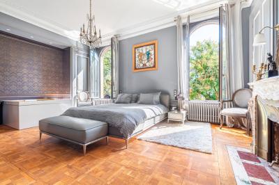 Salle de bain moderne avec carrelage marron, baignoire, fenêtre lumineuse, sèche-serviettes blanc et meuble en bois.