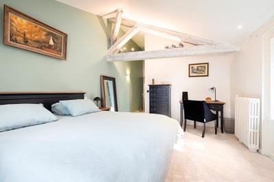Salle de bain moderne avec carrelage marron, baignoire, fenêtre lumineuse, sèche-serviettes blanc et meuble en bois.
