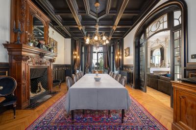 Salle de bain moderne avec carrelage marron, baignoire, fenêtre lumineuse, sèche-serviettes blanc et meuble en bois.