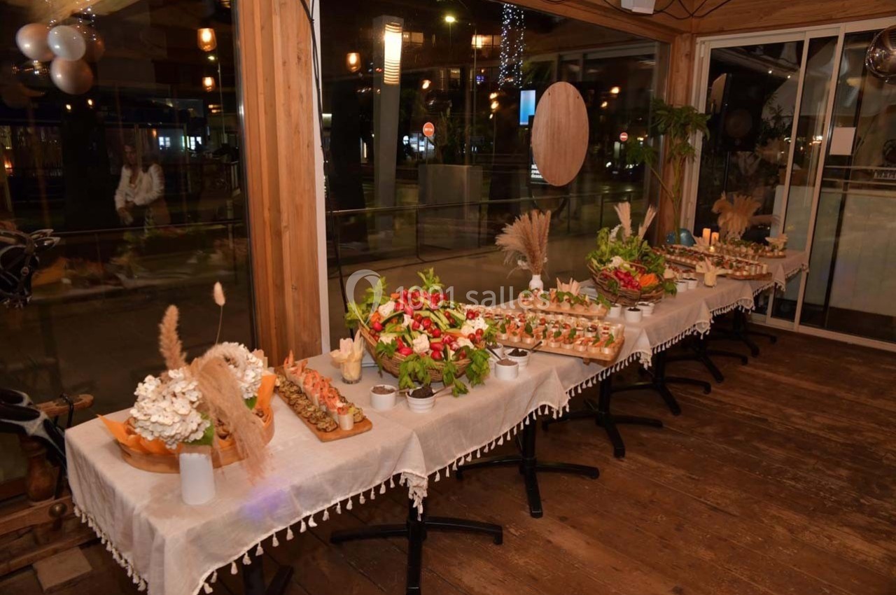Table garnie de plats variés, comprenant des légumes, des amuse-bouches et des décorations naturelles dans un cadre…