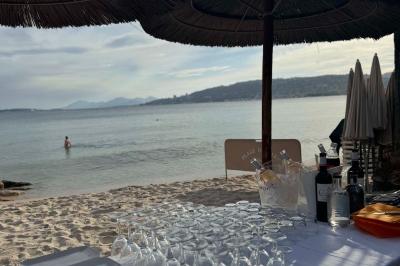 Plateau en bois avec verrines garnies de crevettes, tomates, olives et herbes fraîches, disposées sur une nappe beige.