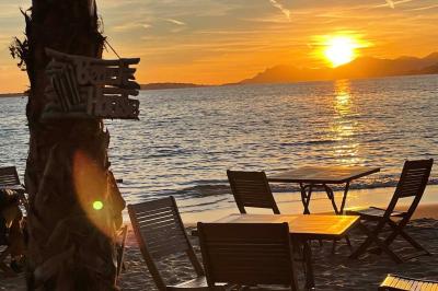 Plateau en bois avec verrines garnies de crevettes, tomates, olives et herbes fraîches, disposées sur une nappe beige.