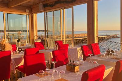 Plateau en bois avec verrines garnies de crevettes, tomates, olives et herbes fraîches, disposées sur une nappe beige.