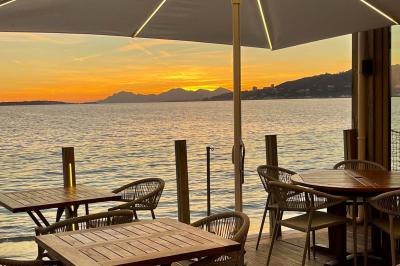 Plateau en bois avec verrines garnies de crevettes, tomates, olives et herbes fraîches, disposées sur une nappe beige.