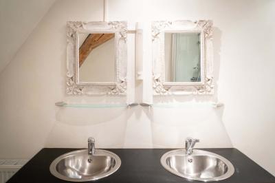 Trampoline rond avec filet de sécurité installé dans un jardin verdoyant, près d'une maison en pierre.