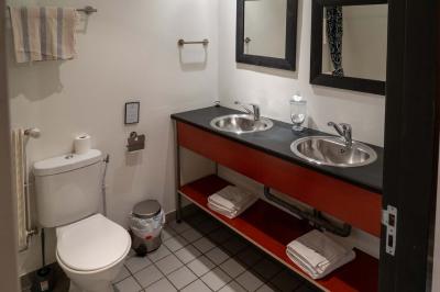 Trampoline rond avec filet de sécurité installé dans un jardin verdoyant, près d'une maison en pierre.