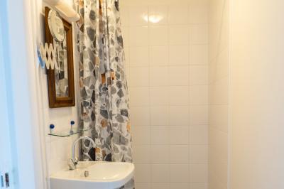 Trampoline rond avec filet de sécurité installé dans un jardin verdoyant, près d'une maison en pierre.