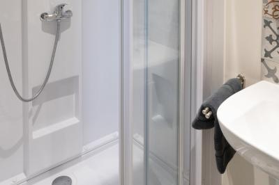 Trampoline rond avec filet de sécurité installé dans un jardin verdoyant, près d'une maison en pierre.