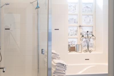 Trampoline rond avec filet de sécurité installé dans un jardin verdoyant, près d'une maison en pierre.