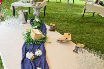 Trampoline rond avec filet de sécurité installé dans un jardin verdoyant, près d'une maison en pierre.