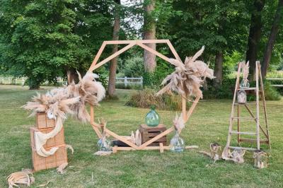 Trampoline rond avec filet de sécurité installé dans un jardin verdoyant, près d'une maison en pierre.