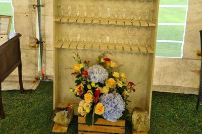 Trampoline rond avec filet de sécurité installé dans un jardin verdoyant, près d'une maison en pierre.