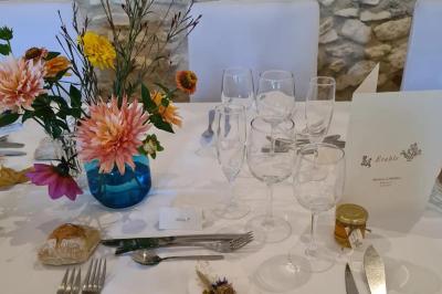 Trampoline rond avec filet de sécurité installé dans un jardin verdoyant, près d'une maison en pierre.