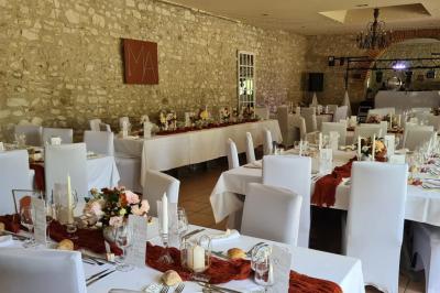 Trampoline rond avec filet de sécurité installé dans un jardin verdoyant, près d'une maison en pierre.