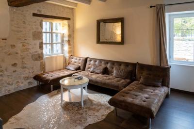 Chambre lumineuse avec deux lits simples, un miroir mural, un fauteuil en osier et un tableau décoratif.