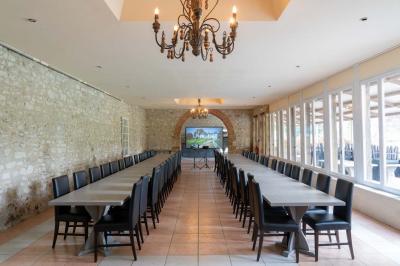 Chambre lumineuse avec deux lits simples, un miroir mural, un fauteuil en osier et un tableau décoratif.