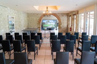 Chambre lumineuse avec deux lits simples, un miroir mural, un fauteuil en osier et un tableau décoratif.