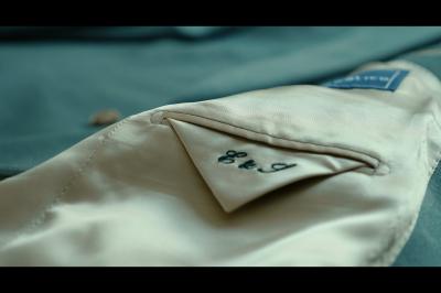 Chaussures blanches à talons posées sur un sol en bois, près d'une robe en tissu léger.