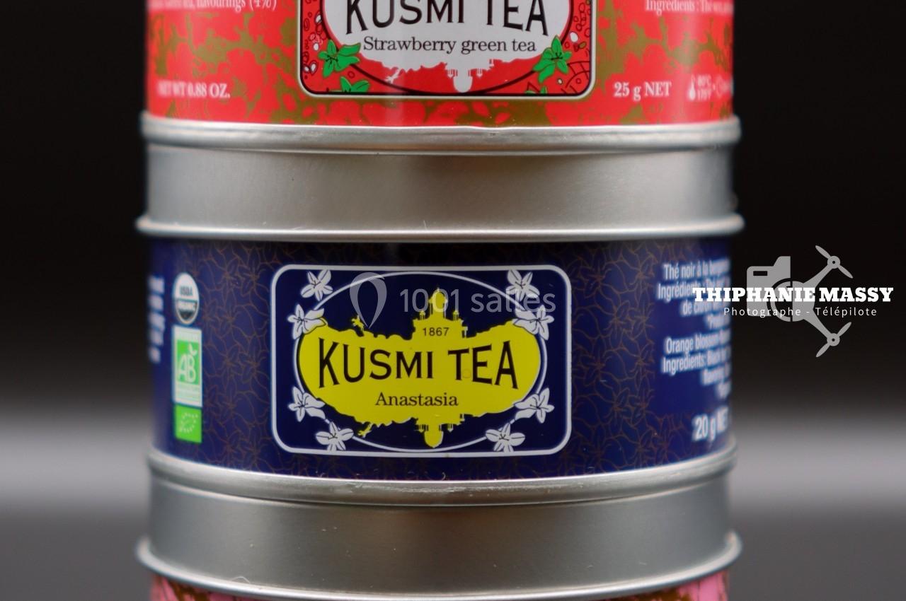 Trois boîtes métalliques empilées de thé Kusmi Tea aux étiquettes colorées indiquant différentes saveurs.