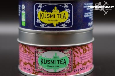 Deux boîtes de thé Kusmi Tea empilées, l'une bleue ’Anastasia’ et l'autre rose ’Green Rose’.