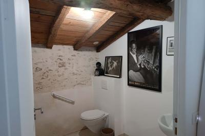 Salle lumineuse avec poutres apparentes, tables dressées et grande baie vitrée donnant sur un extérieur verdoyant.