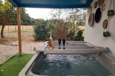 Salle lumineuse avec poutres apparentes, tables dressées et grande baie vitrée donnant sur un extérieur verdoyant.