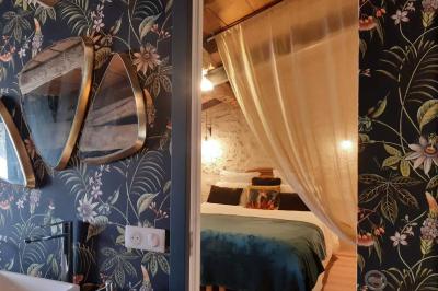 Salle lumineuse avec poutres apparentes, tables dressées et grande baie vitrée donnant sur un extérieur verdoyant.