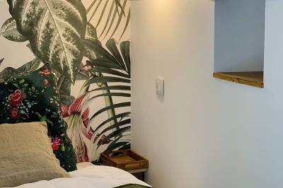 Salle lumineuse avec poutres apparentes, tables dressées et grande baie vitrée donnant sur un extérieur verdoyant.