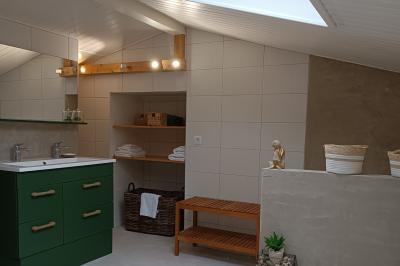 Salle lumineuse avec poutres apparentes, tables dressées et grande baie vitrée donnant sur un extérieur verdoyant.