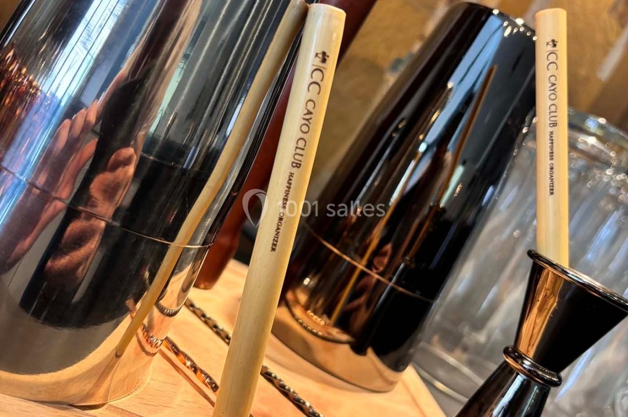 Deux bâtons en bois gravés entourés d'ustensiles métalliques brillants sur une surface en bois.