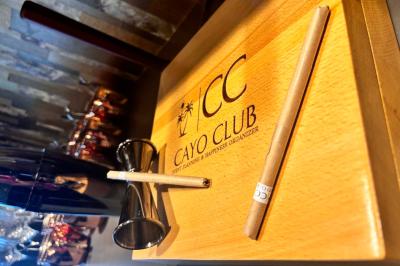 Logo circulaire de Cayo Club avec des palmiers, un soleil et le texte ’Event Planning & Happiness Organizer’.