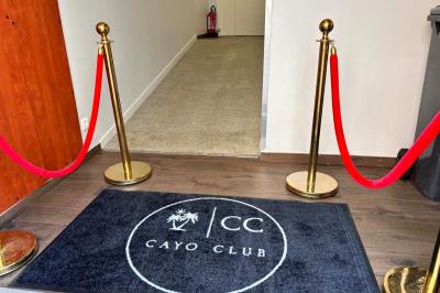 Logo circulaire de Cayo Club avec des palmiers, un soleil et le texte ’Event Planning & Happiness Organizer’.