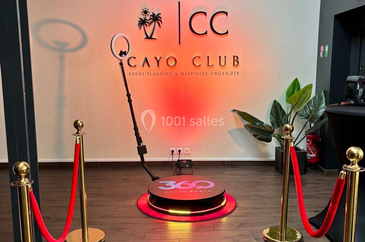 Plateforme photo 360° entourée de cordons rouges dans un espace événementiel décoré avec un logo mural.