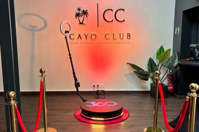 Logo circulaire du Cayo Club avec des palmiers, un soleil et le texte ’Event Planning & Happiness Organizer’.