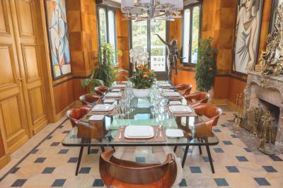 Salle de bain luxueuse avec baignoire en marbre, double vasque, miroirs, et fenêtre donnant sur un jardin.