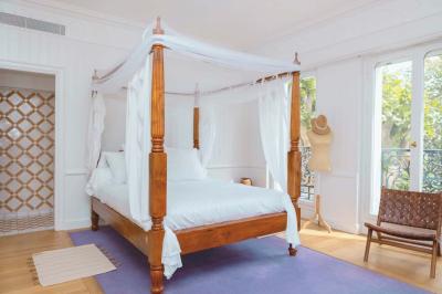 Salle de bain luxueuse avec baignoire en marbre, double vasque, miroirs, et fenêtre donnant sur un jardin.
