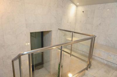 Salle de bain luxueuse avec baignoire en marbre, double vasque, miroirs, et fenêtre donnant sur un jardin.