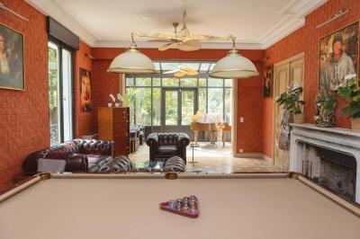 Salle de bain luxueuse avec baignoire en marbre, double vasque, miroirs, et fenêtre donnant sur un jardin.