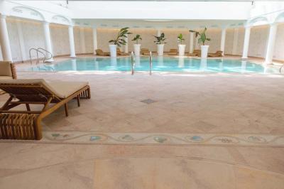 Salle de bain luxueuse avec baignoire en marbre, double vasque, miroirs, et fenêtre donnant sur un jardin.