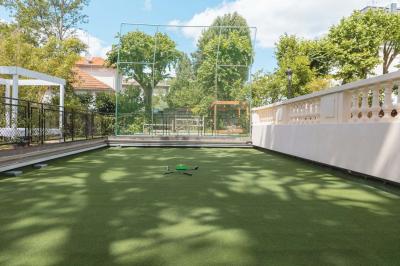 Salle de bain luxueuse avec baignoire en marbre, double vasque, miroirs, et fenêtre donnant sur un jardin.