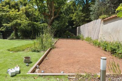 Salle de bain luxueuse avec baignoire en marbre, double vasque, miroirs, et fenêtre donnant sur un jardin.
